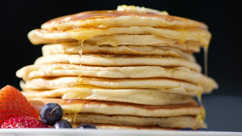 A stack of pancakes covered in syrup.
