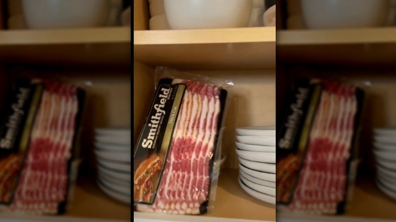 A package of bacon sitting in a person's kitchen cupboard.