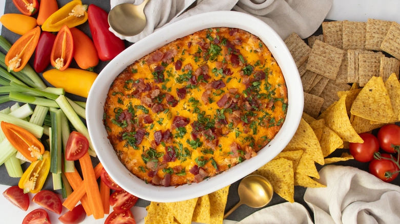 Chicken bacon ranch dip surrounded by veggies, chips, and crackers