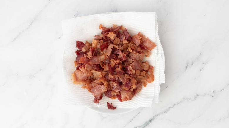Cooked chopped bacon on paper towel lined plate