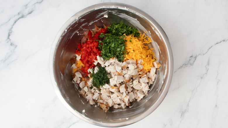 Chicken, cheese, herbs, and pimento peppers in bowl