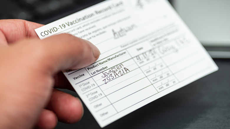 person holding COVID vaccination card