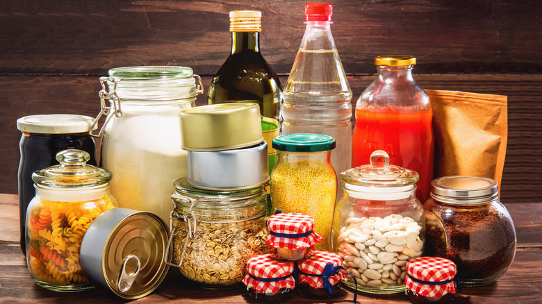 Various types of canned or preserved foods on wood background