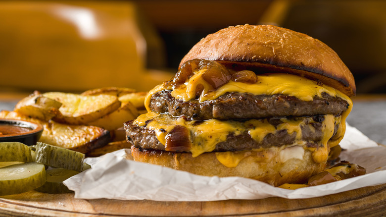 Smash burger with cheese, onions, and fries.
