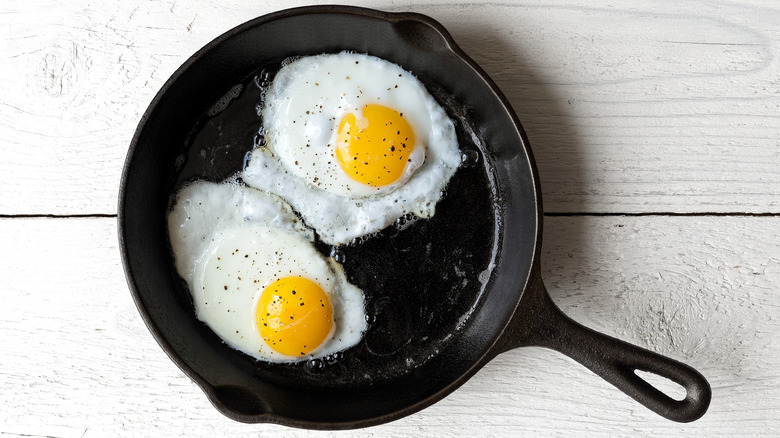 Eggs frying in a cast iron skillet