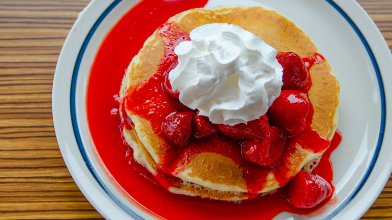 IHOP pancakes with whipped cream and strawberry syrup