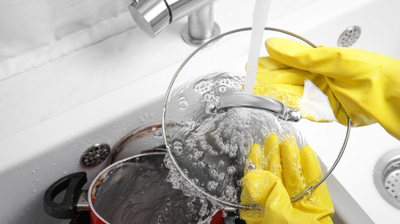 Rinsing off a pot lid with water