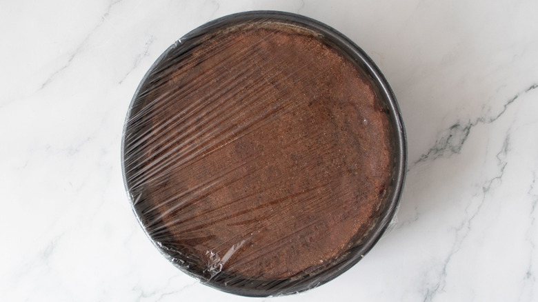 Cinnamon sugar cheesecake covered with plastic wrap