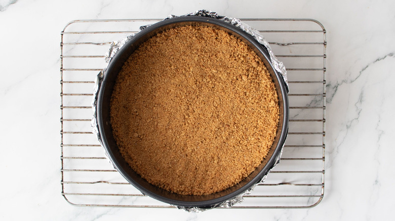 Graham cracker crust in springform pan on wire rack