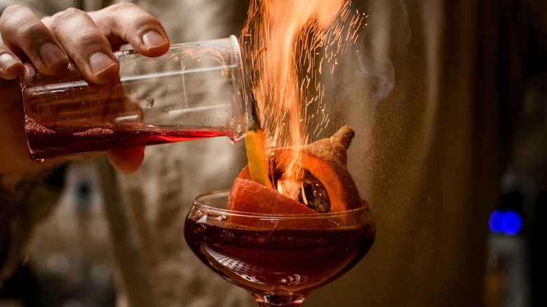 Bartender making flaming cocktail.