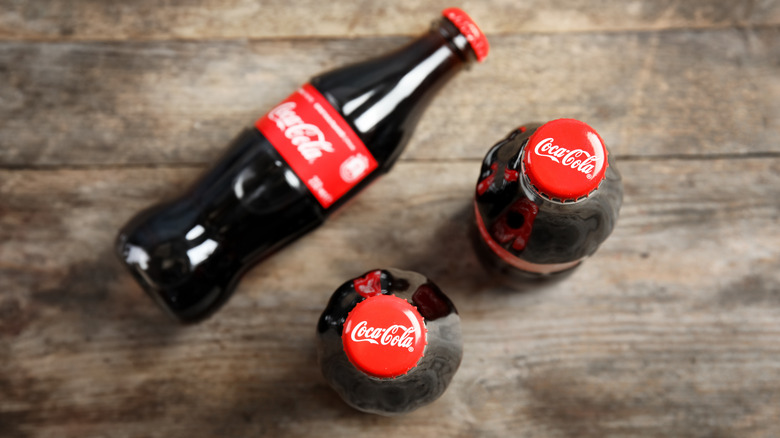 Coke bottles against wooden background