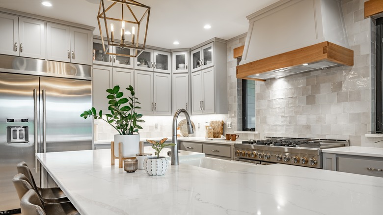 Modern day kitchen with marble counters and light fixtures