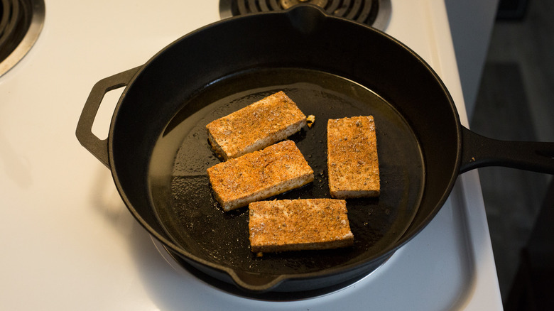 tofu frying in iron pan
