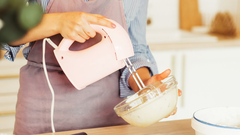 Woman using electric mixer