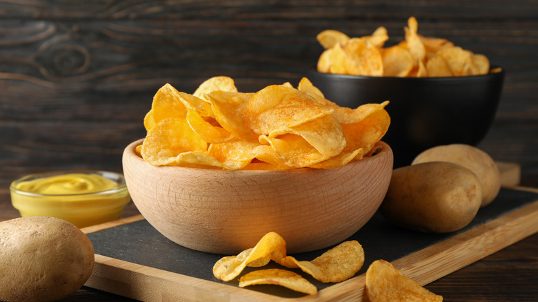 Potato chips and mustard dip on wood table