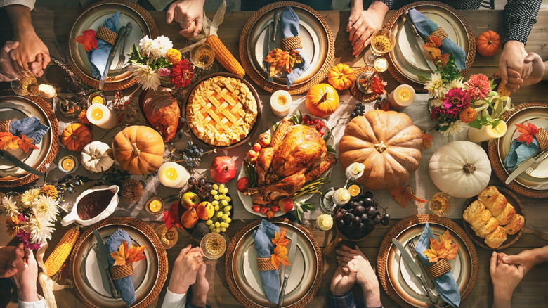 People holding hands around Thanksgiving table