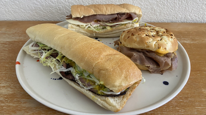 Three different roast beef sandwiches are laid out on a plate.