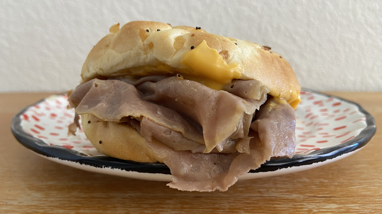 Arby's Beef 'N Cheddar sandwich stuffed with roast beef and melted cheese, topped with black seeds.