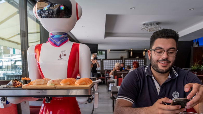 A robot delivering food to a customer in a restaurant