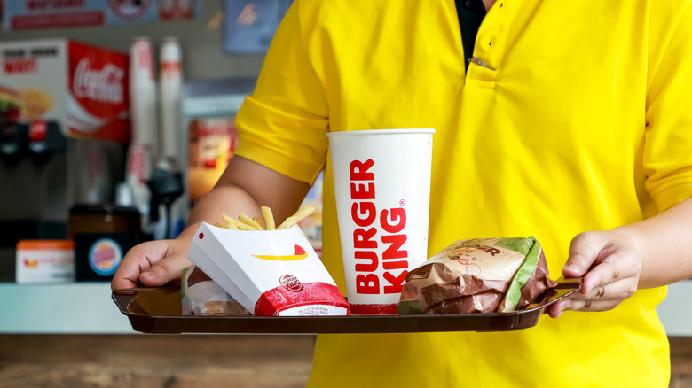 Person in yellow carrying Burger King food