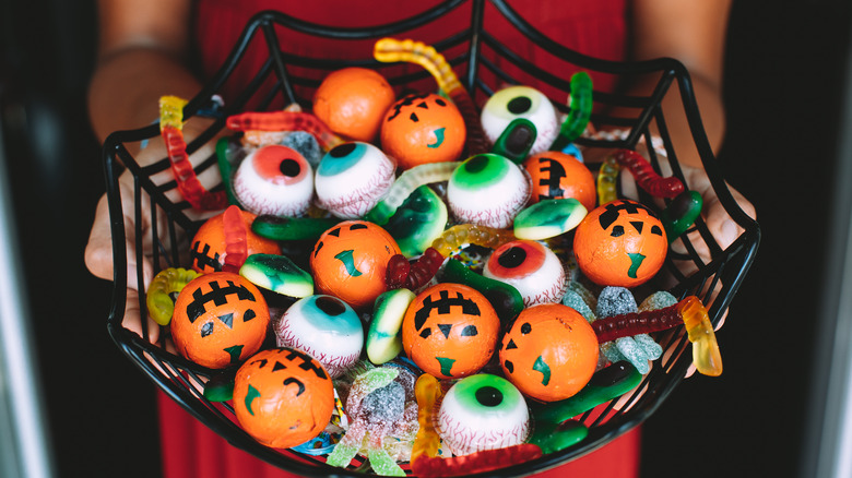 Assorted Halloween candy in spider web bowl 