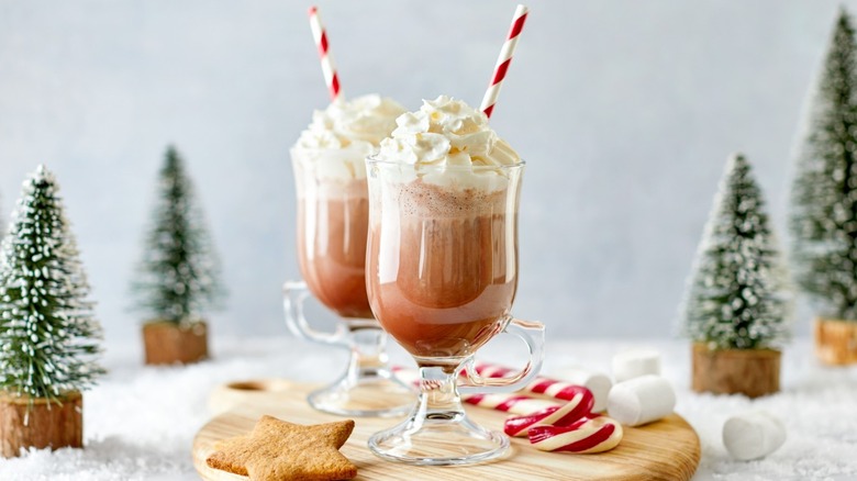 Two mugs of hot chocolate with striped straws