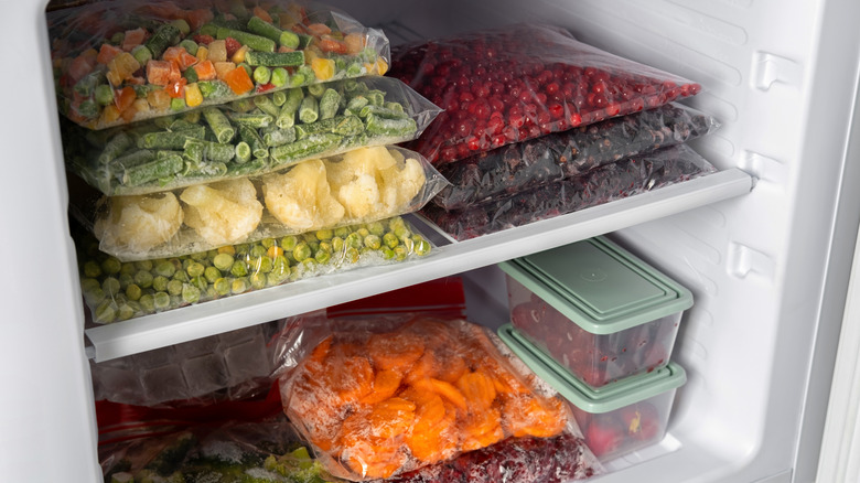 Bags of frozen fruit and vegetables in freezer