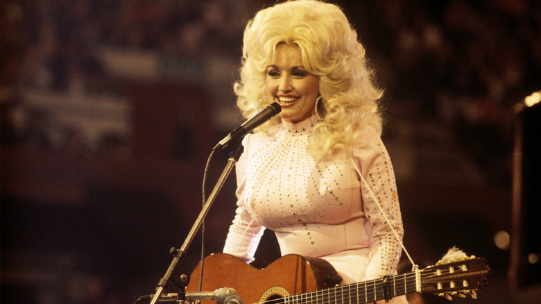 Dolly Parton smiling on stage at a concert.