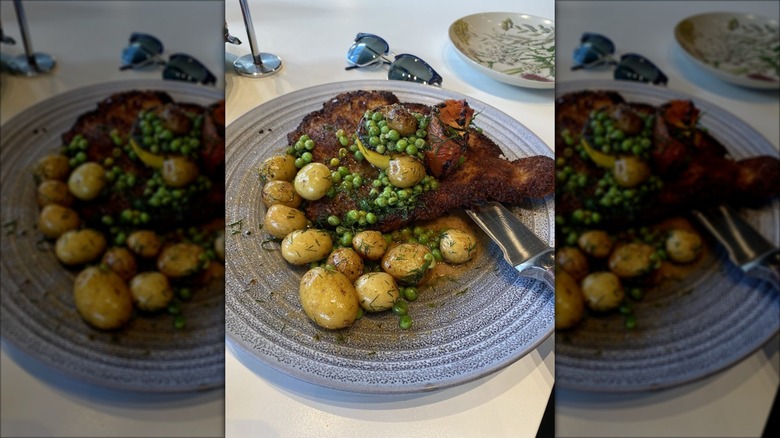 Wienerschnitzel on plate with peas and potatoes