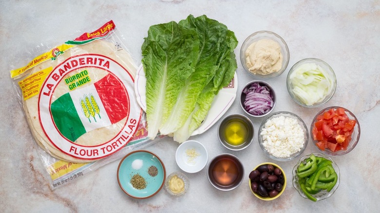 Ingredients for greek salad wraps on countertop