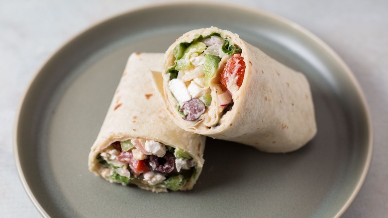 halved greek salad wrap on plate