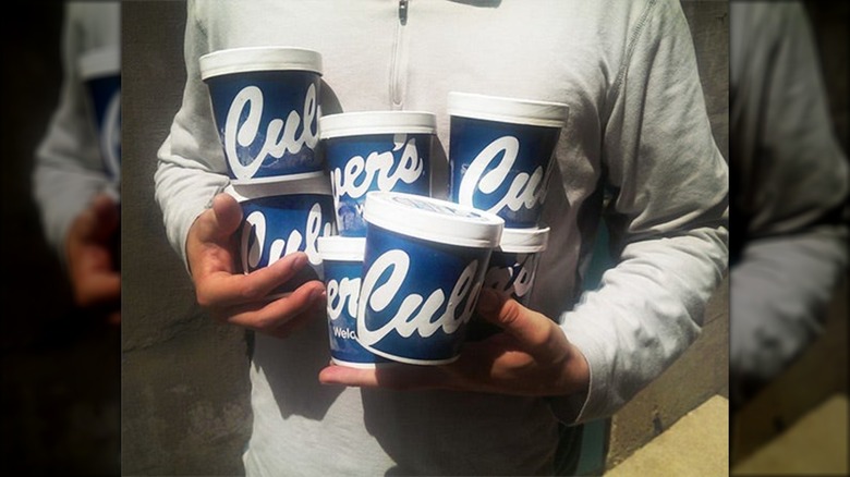 Person holding several pints of Culver's custard.