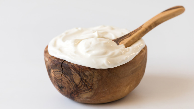 Bowl of Greek yogurt with wooden spoon