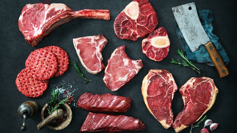 A display of raw meat next to butcher knife