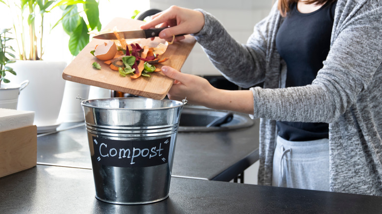 Putting food scraps in compost bucket