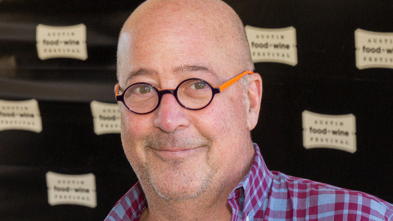 Andrew Zimmern wearing glasses and plaid shirt