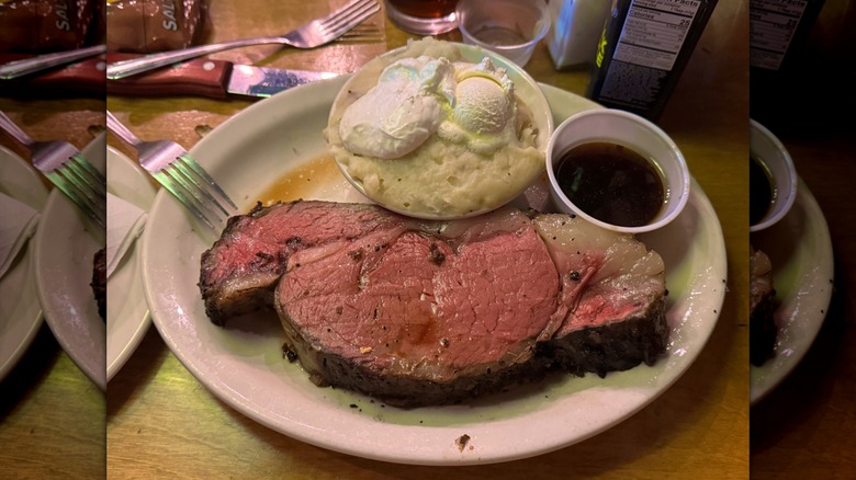 prime rib steak with mashed potatoes on plate in restaurant