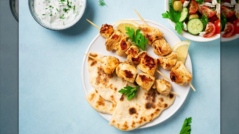 naan with chicken kebabs salad and tzatziki