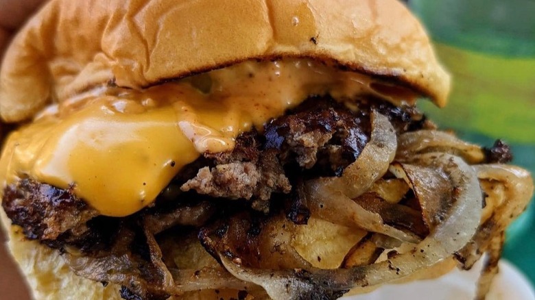 Close-up of cheesy burger with onions