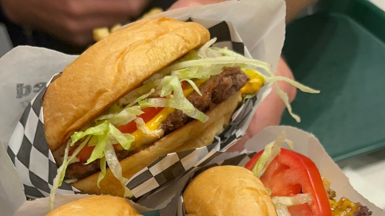 Handheld burger in paper wrappings