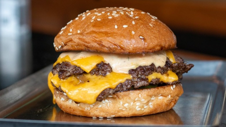 Burger with cheese on metal tray