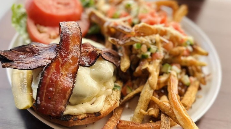 Bacon cheeseburger plated with fries