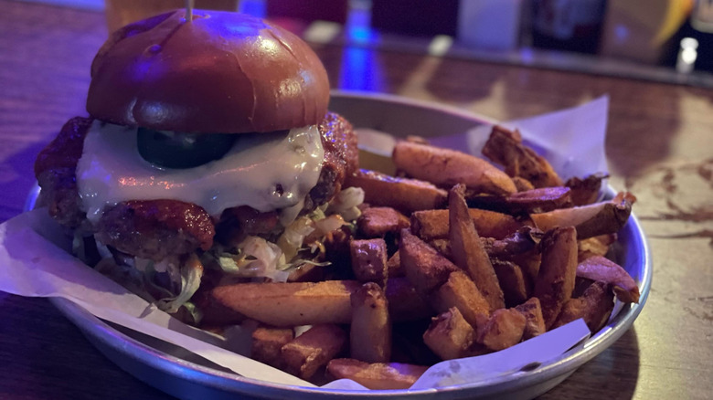 Gooey burger with fries on plate