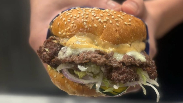 Hand holding gooey burger