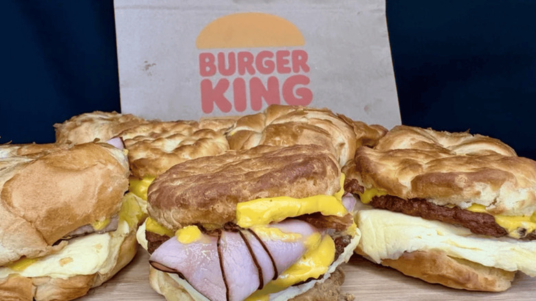 Assorted Burger King breakfast sandwiches with Burger King bag in background.