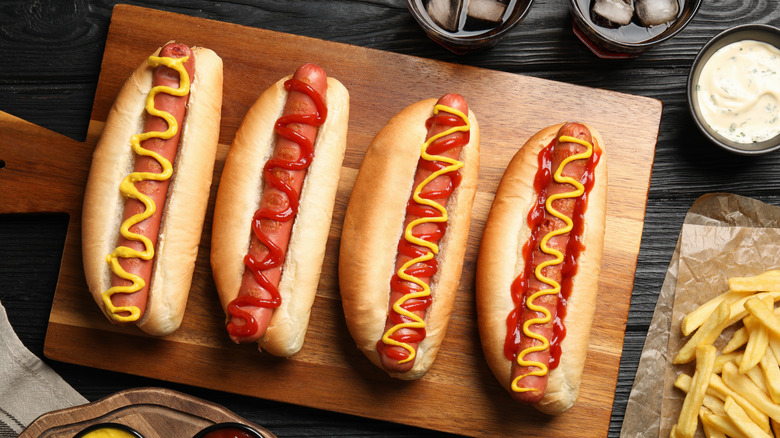 Hot dogs with various topping on cutting board