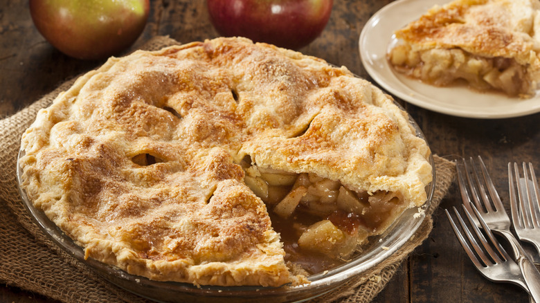 A fresh baked apple pie with a slice taken out