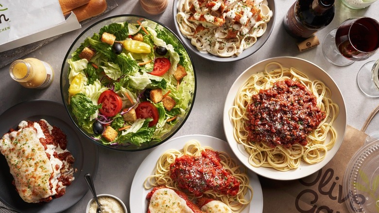 Olive Garden salad and assorted pastas on a table