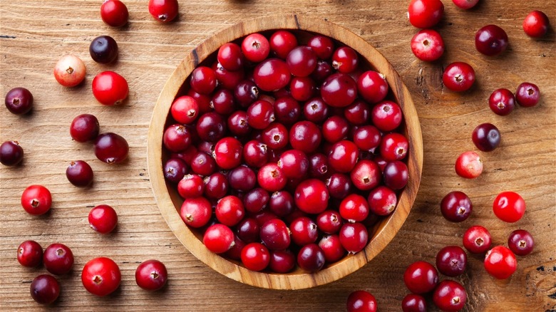 Wooden bowl full of fresh cranberries