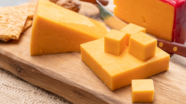 Blocks of cheese on a wooden cutting board